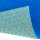 Eine Hand hält ein gelbes Teppichmesser und schneidet damit einen grünen Kunstrasen. Oben steht der Text „Einfach zu Verlegen“, unten links ein roter Kreis mit dem Text „Mit dem Messer schneidbar“.