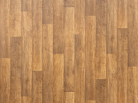 Mehrere Bodenbeläge in verschiedenen Designs sind ausgebreitet zu sehen. Im Hintergrund liegt ein großflächiger PVC-Boden in Holzoptik, im Vordergrund sind Musterstücke mit unterschiedlichen Strukturen und Farben, darunter Stein-, Holz-, Beton- und Fliesenmuster, sowie ein schwarz-weiß kariertes Design.