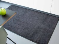 Rechteckiger Teppich mit kurzem, dichtem Flor in hellgrüner Farbe und einer dunklen, schmalen Umrandung auf einem weißen Hintergrund.