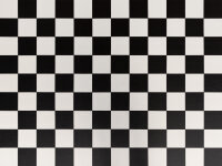 Boden und Wand mit einem schwarz-weißen Schachbrettmuster aus quadratischen Feldern. Die Karos sind regelmäßig und wechseln sich ab. Die Perspektive vermittelt einen Eindruck von Tiefe.