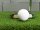 Eine Nahaufnahme zeigt einen violetten Minigolfball auf grünem Kunstrasen, daneben ein silberner Minigolfschläger und das Loch mit weißer Umrandung.
